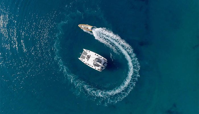 Vista cenital del catamaran con una lancha que lo rodea
